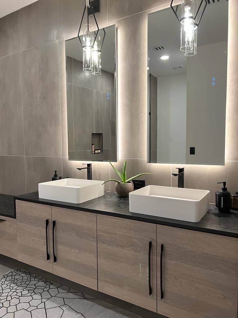 Double vanity with vessel sinks, backlit mirrors and glass pendant lights