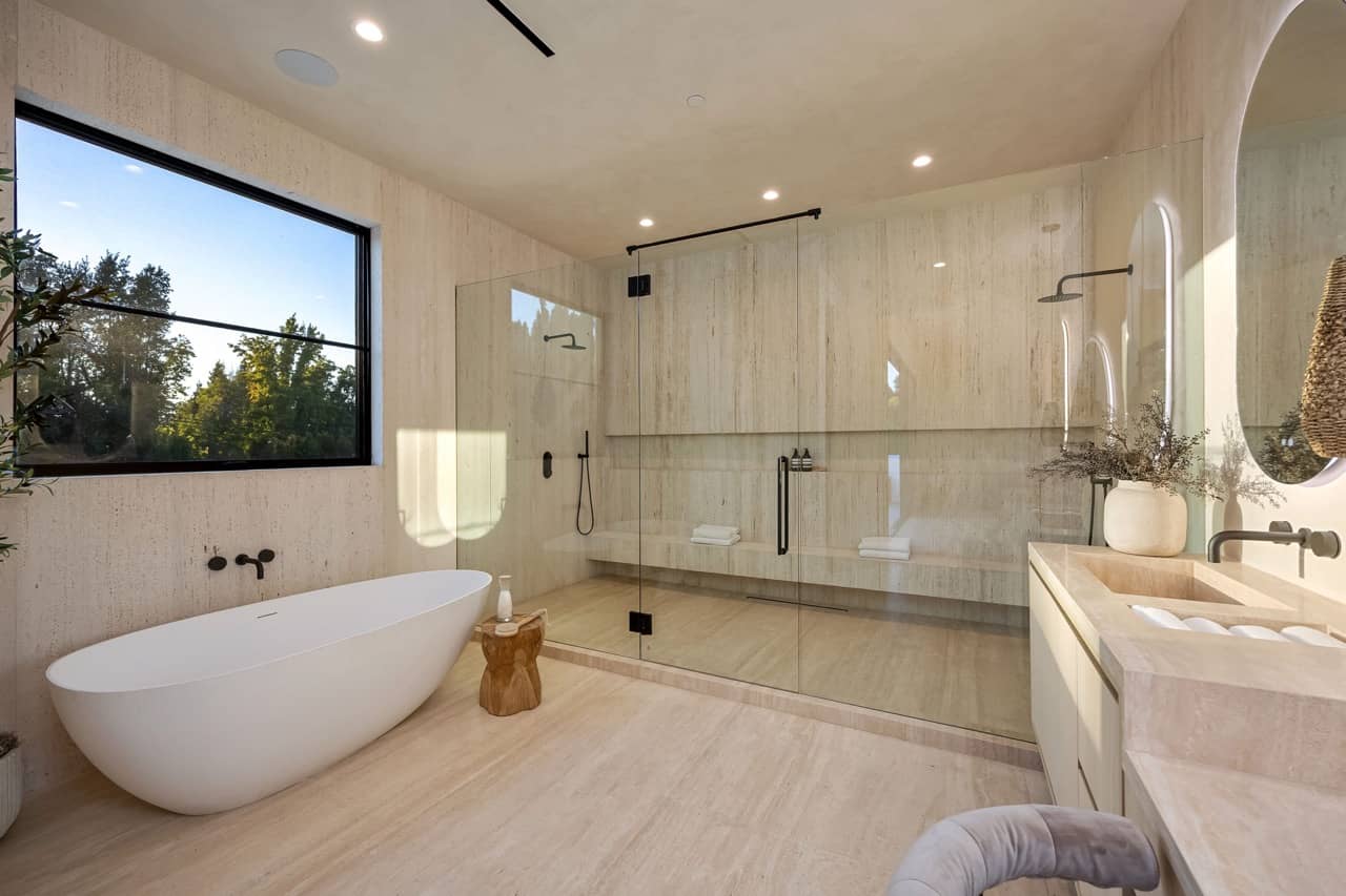 Primary bathroom with a freestanding tub, a walk-in shower and a large window