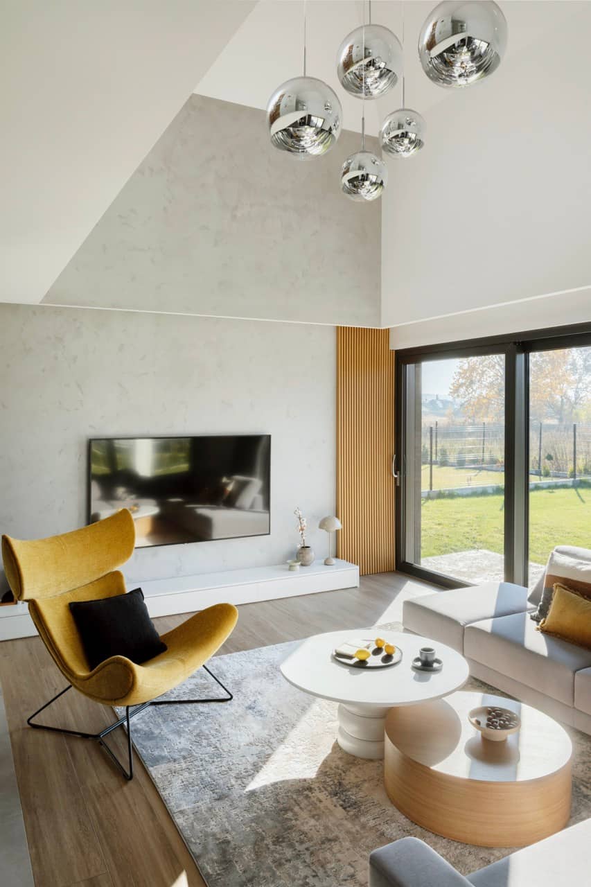 Living room with a corner sofa, a yellow armchair and tall windows