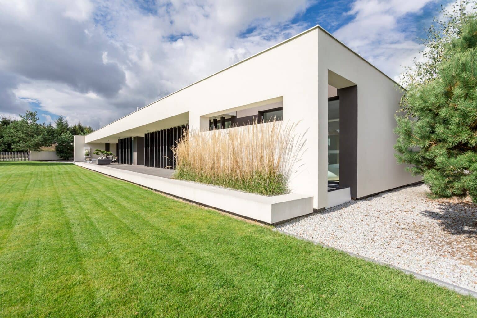 Modern single-story home with a long lawn and ornamental grasses