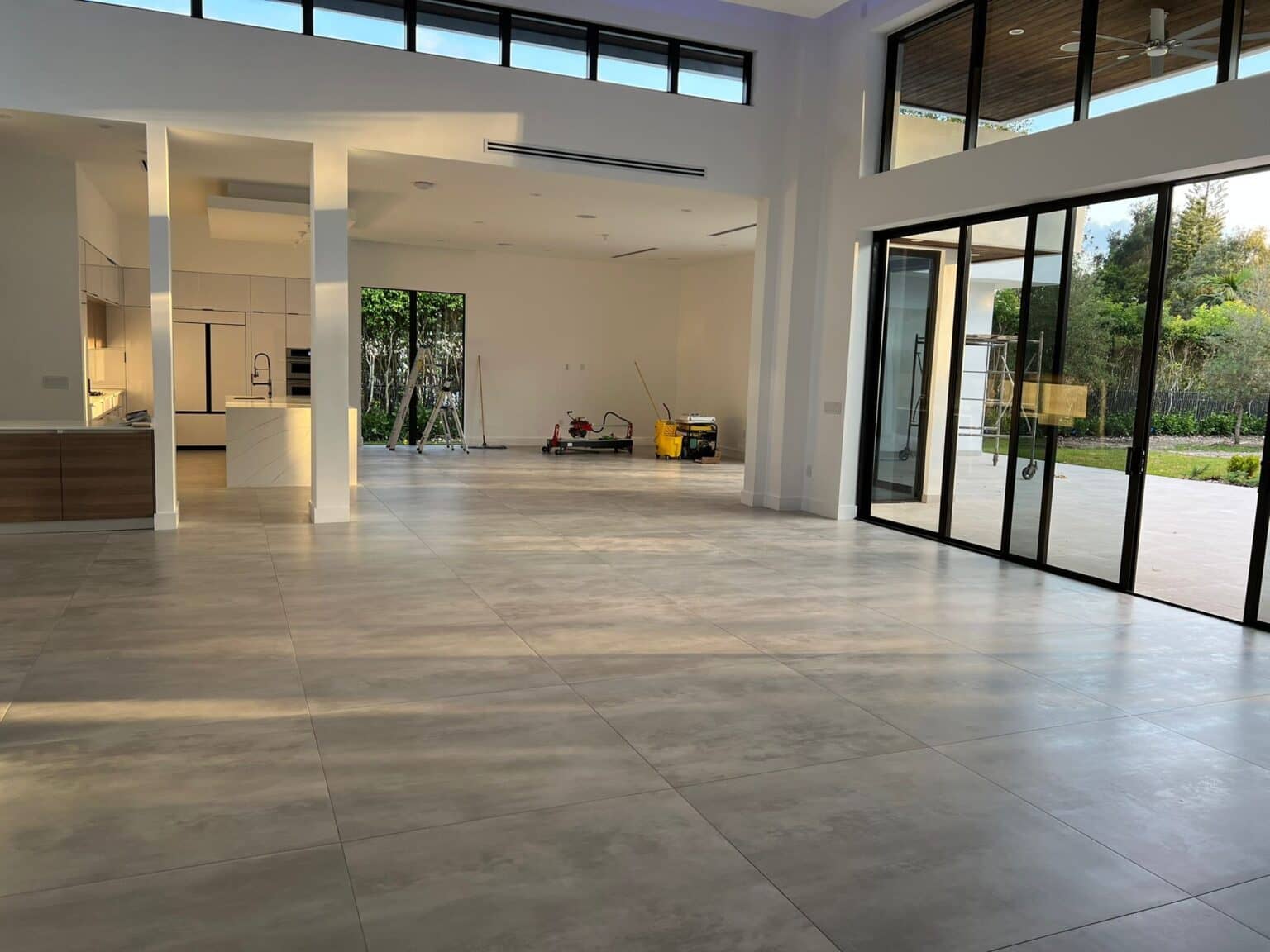 Open-plan great room with clerestory windows, large-format tile floors and floor-to-ceiling sliding glass doors