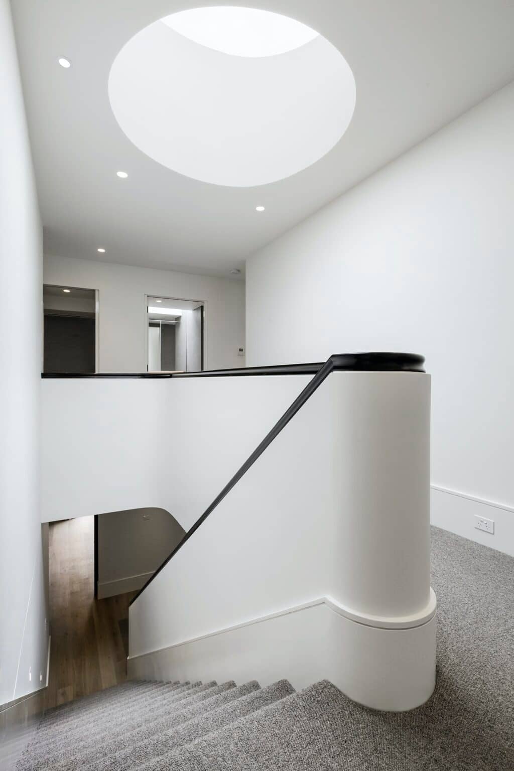 White curved staircase under a round skylight