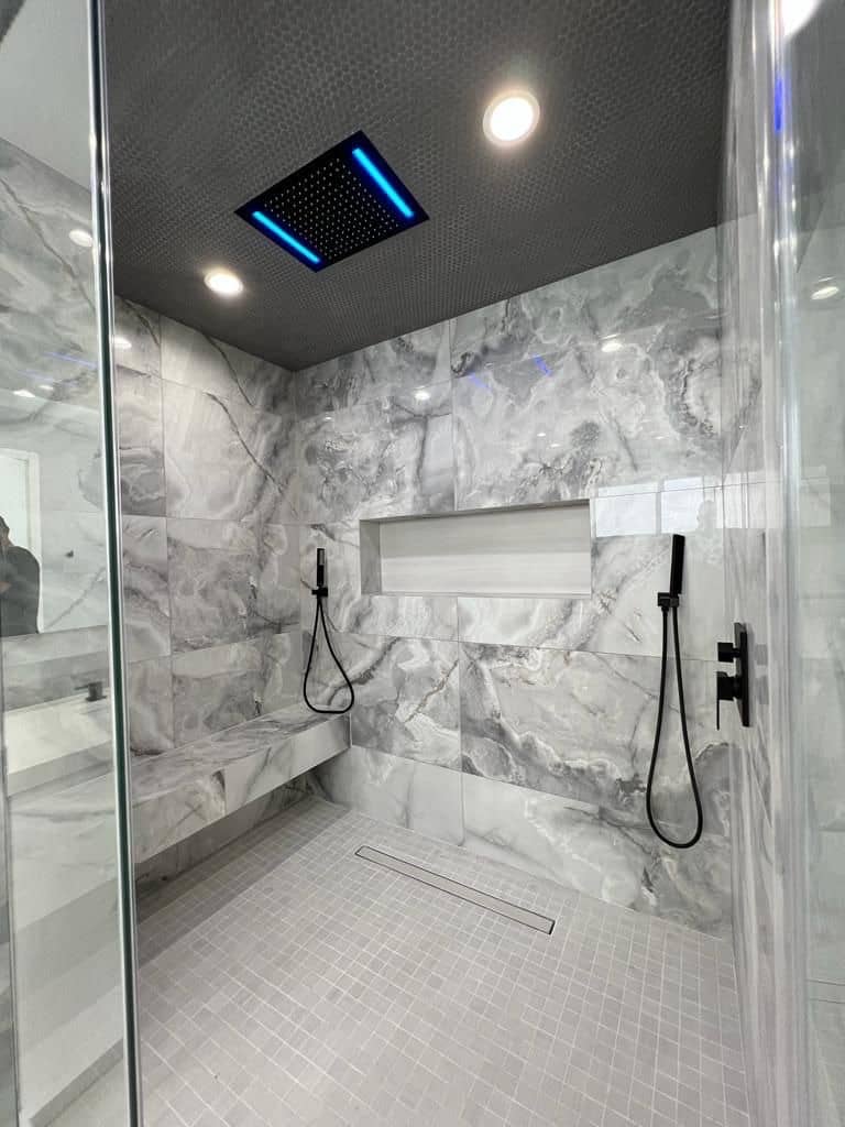 Marble-look walk-in shower with a bench, a wall niche and a ceiling rain shower