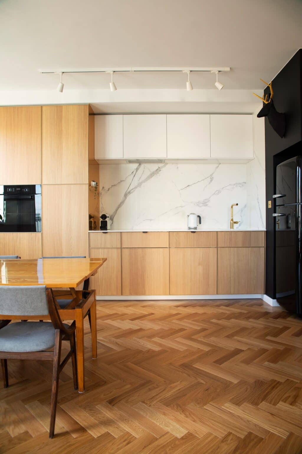 Kitchen and dining area with wood cabinets and a herringbone wood floor