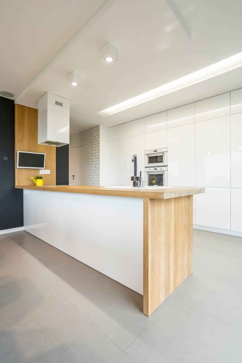 Minimal white kitchen with a wood-topped peninsula